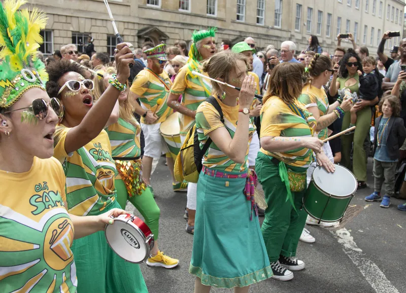 a carnival scene with dancers in bright costumes